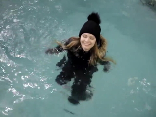 wetlook girl with winter clothes swims